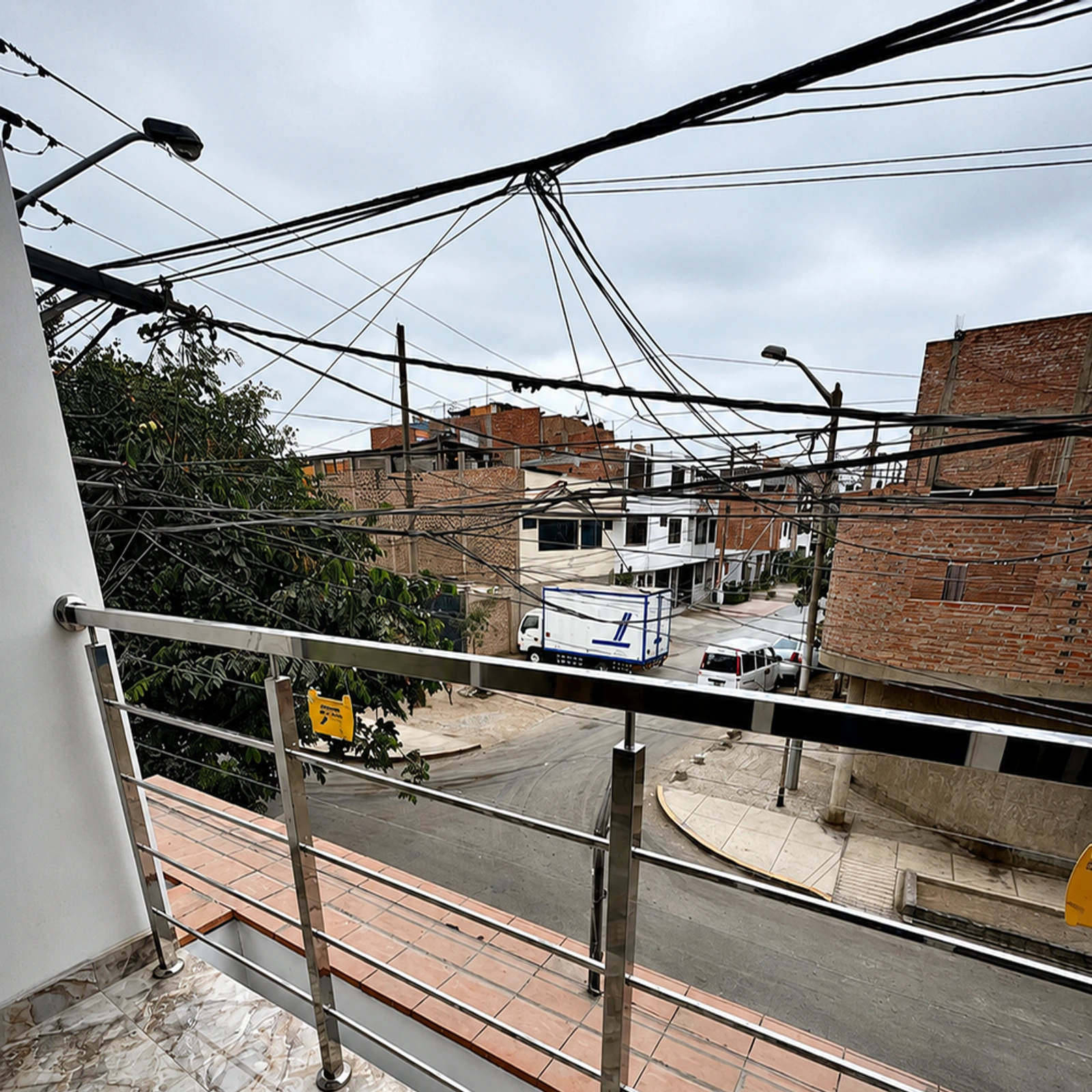 Baranda de acero inoxidable en la terraza de una vivienda, con vista a la calle