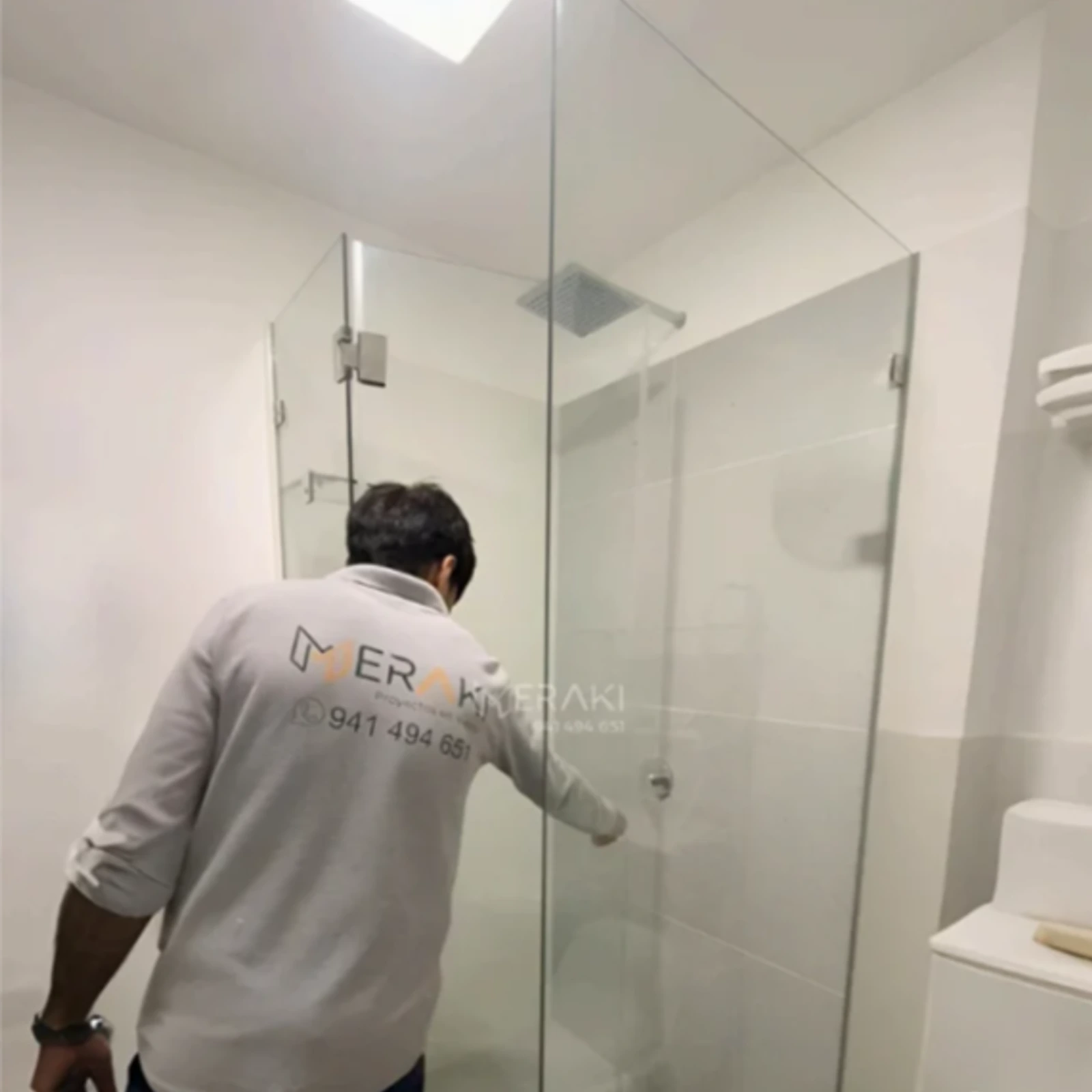 Técnico de Meraki ajustando la puerta de una mampara batiente esquinera