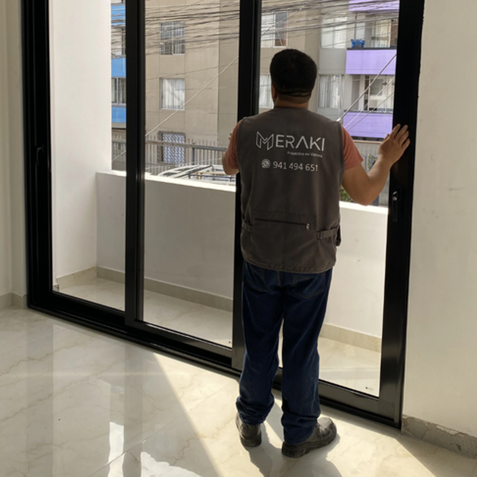 Técnico de Meraki comprobando el deslizamiento de una mampara corrediza de perfilería negra