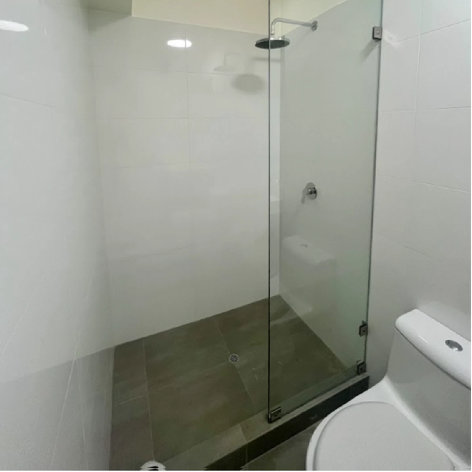 Mampara fija tipo walk-in de vidrio templado sin perfilería, en ducha de obra