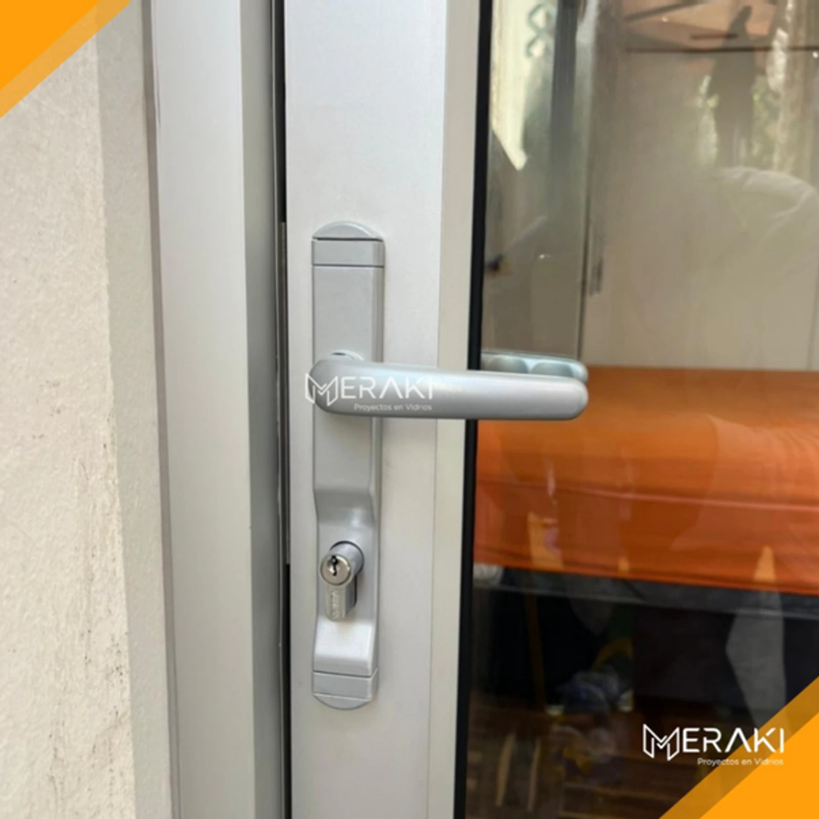 Detalle de la manija y la cerradura de una mampara plegable de aluminio blanco