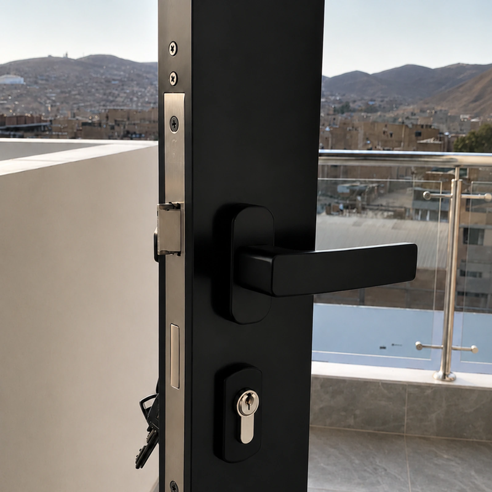 Detalle de la manija y la cerradura de una puerta de aluminio negro