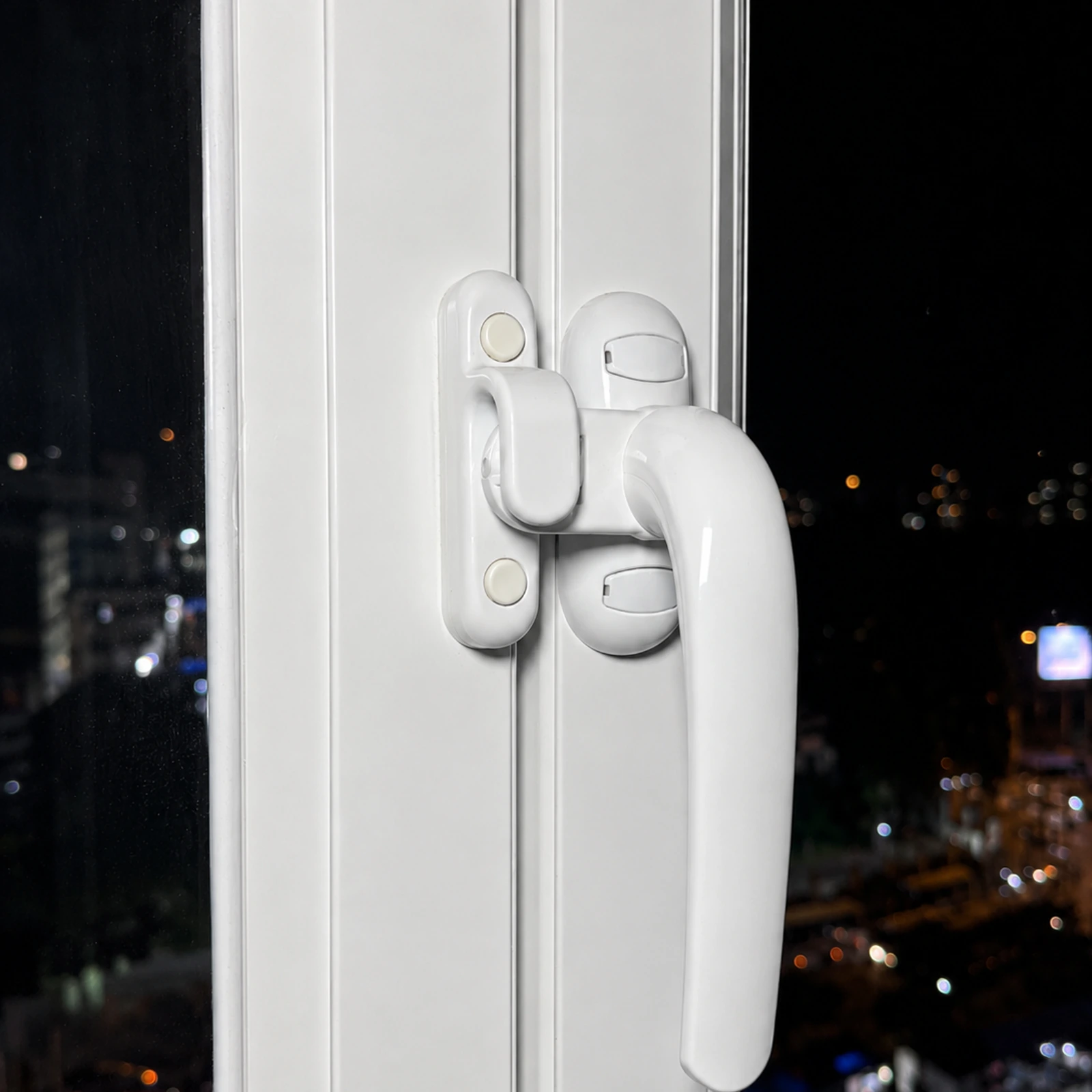 Detalle de la manija de una ventana batiente de aluminio blanco