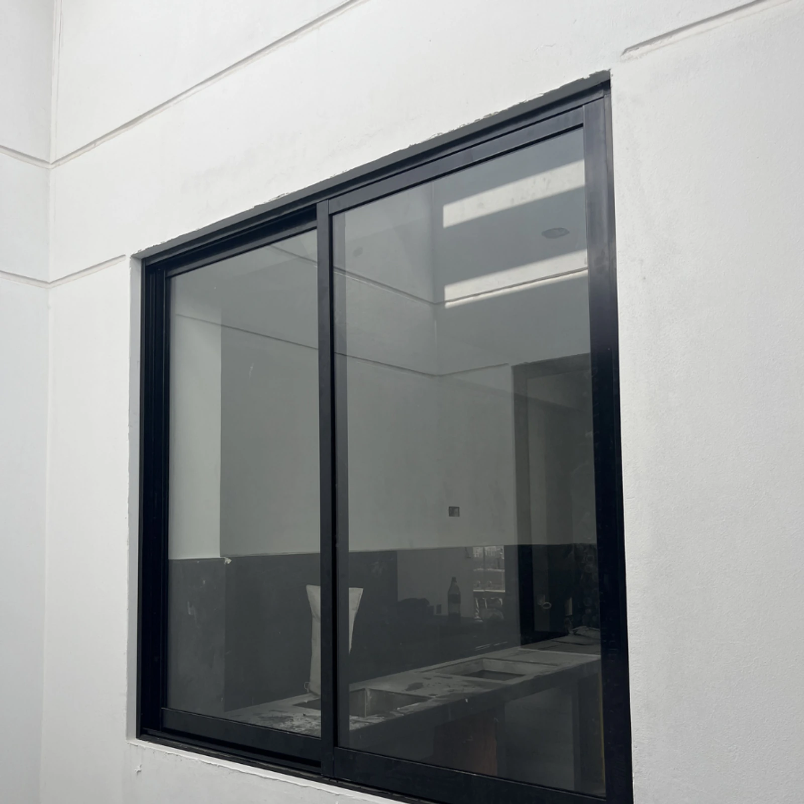 Ventana corrediza de perfilería negra vista de frente desde el interior