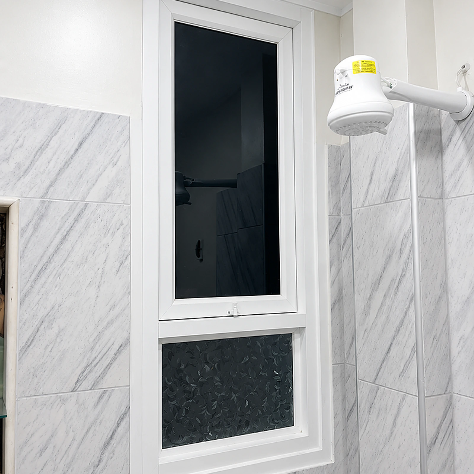 Ventana pivotante de aluminio blanco vista de frente sobre su paño fijo inferior